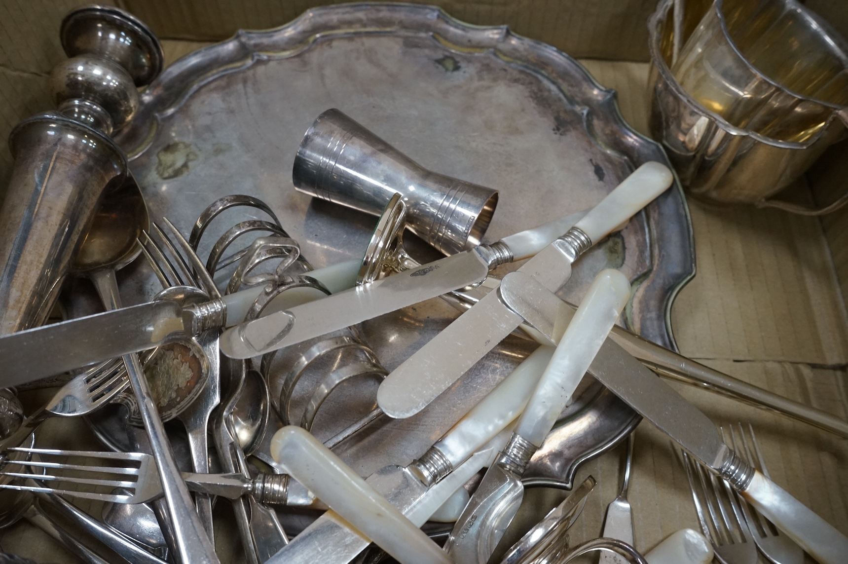 A group of assorted plated ware, including a pair of candlesticks, a salver, toast rack and cutlery including set of mother of pearl handled dessert eaters, together with a George V silver mounted trinket box and two sil